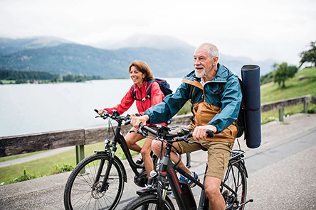 senior-couple-tourist-with-bicycles-cycling-on-road